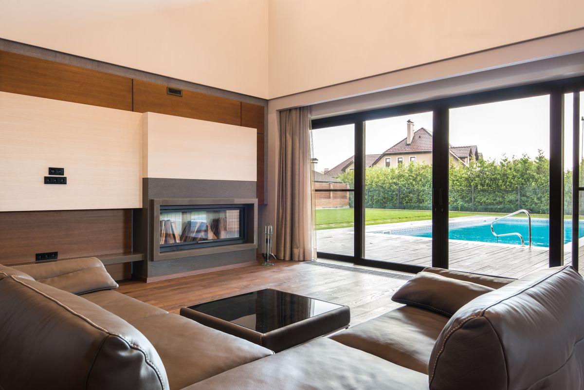 Aluminium bifold doors in a modern living room with large glass panels and pool view