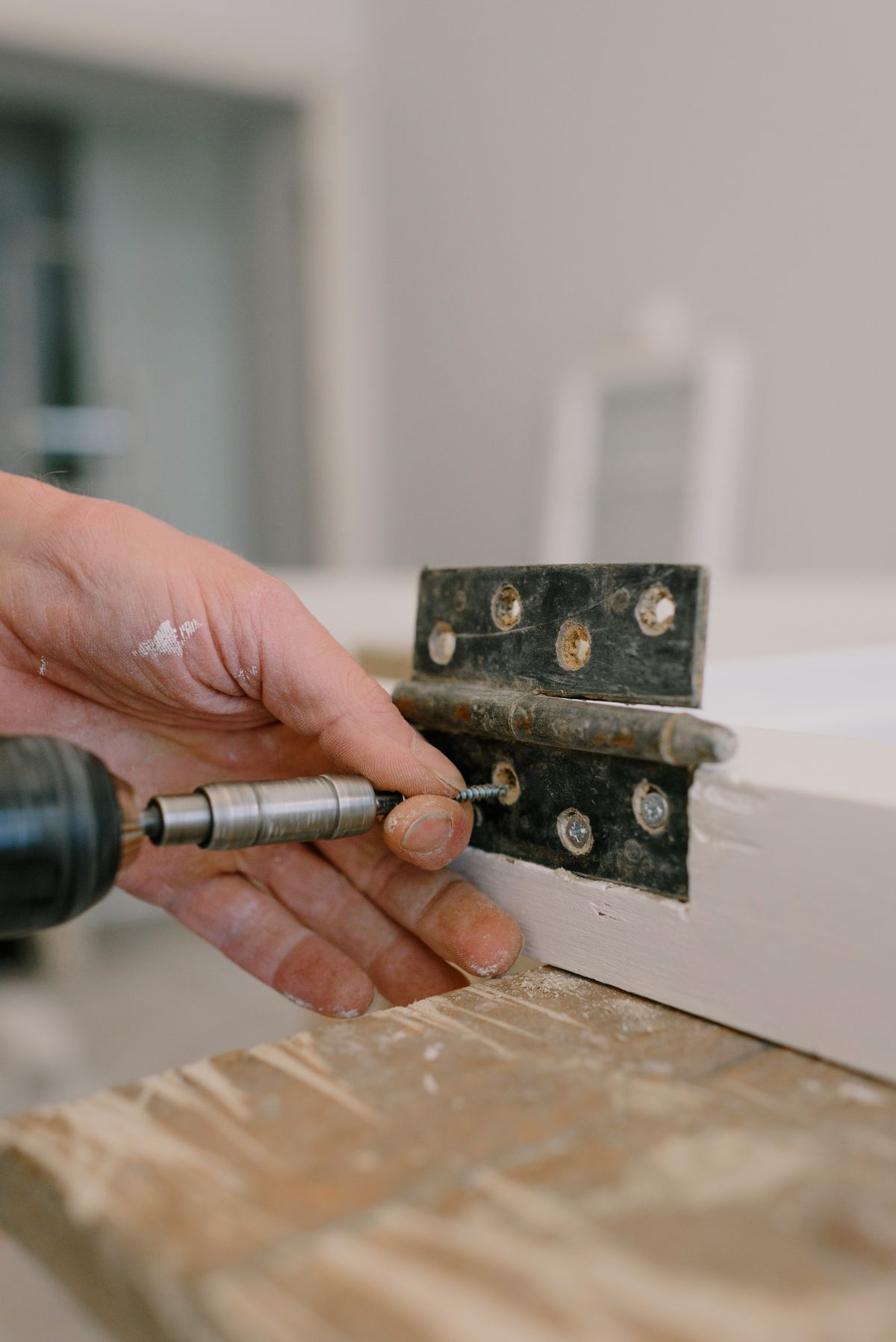 Close-up of metal hinge being installed on aluminium casement window frame