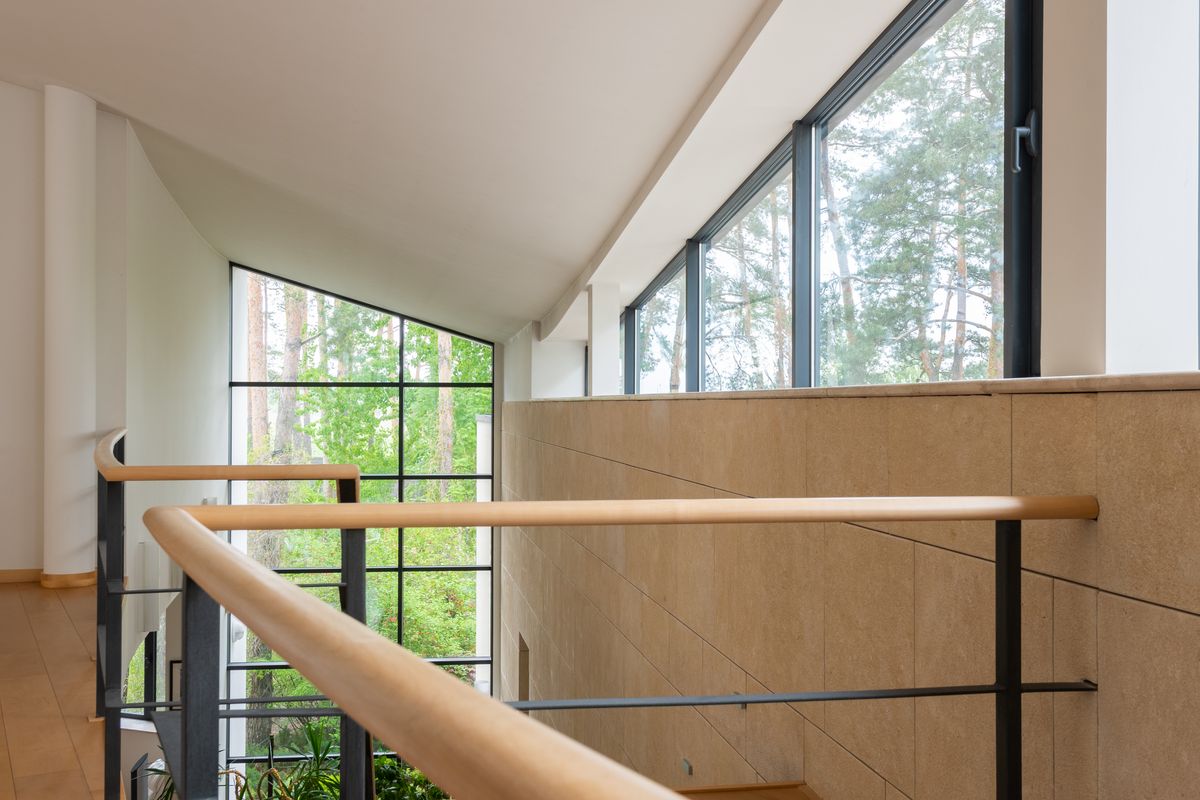 Modern interior with dark aluminium tilt and turn window frames overlooking trees