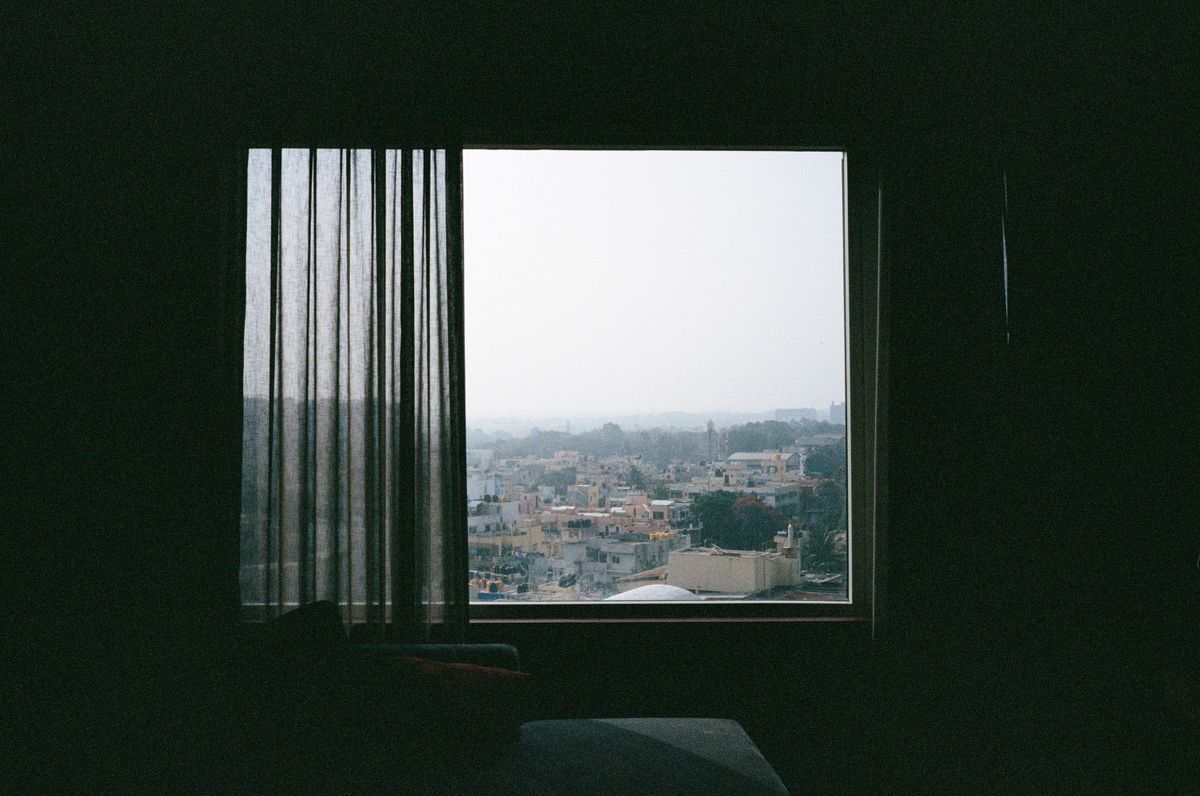 City skyline seen through a high-floor apartment window at dusk