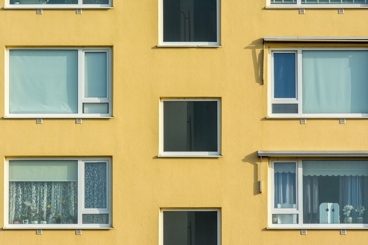 Multi-storey apartment block with uniform white window frames after years of service